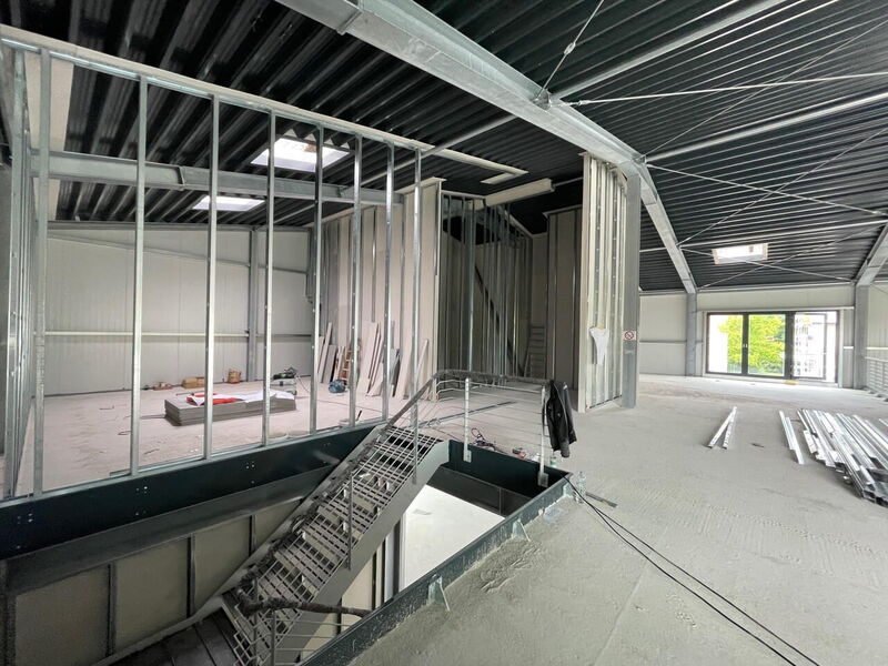 Innenausbau eines Gebäudes mit Metallgerüst für Wände und Decken, Treppe und Dachfenstern